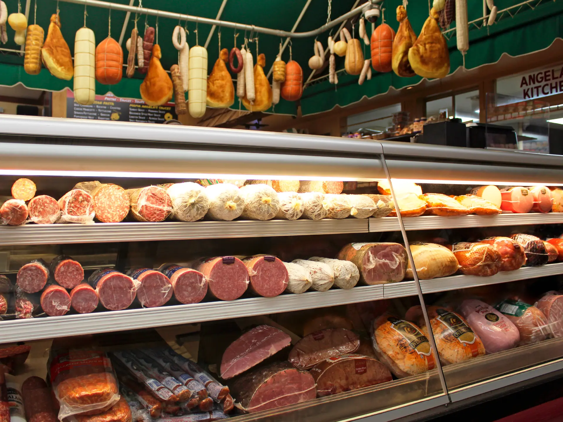 Sliced prosciutto and Italian deli meats at Sam's deli counter