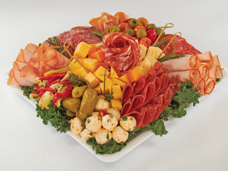 Deli platter with sliced meats, cheese cubes, olives, and marinated mozzarella