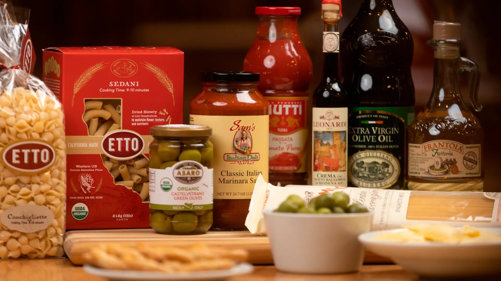Italian pantry staples at Sam's Italian Market — pasta, olive oil, marinara, and olives